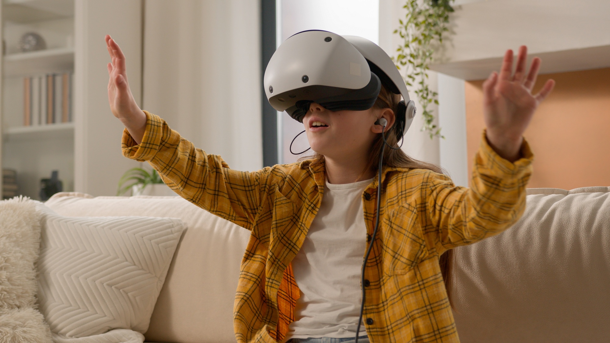 Amazed modern little Caucasian child girl daughter play video game online VR virtual reality glasses
